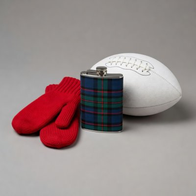 A tartan flask and red mittens beside a white football on a plain grey surface